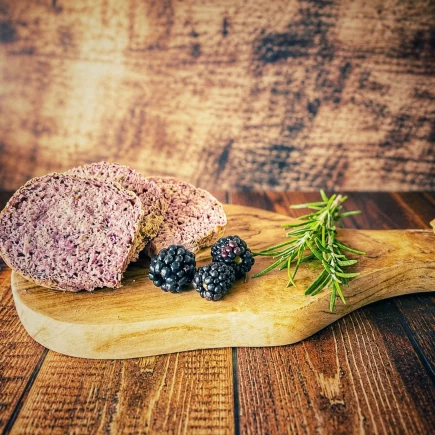 Brombeer-Rosmarin-Brot mit saftiger violetter Krume auf einem Holzbrett