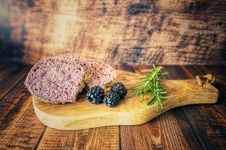 Brombeer-Rosmarin-Brot mit saftiger violetter Krume auf einem Holzbrett