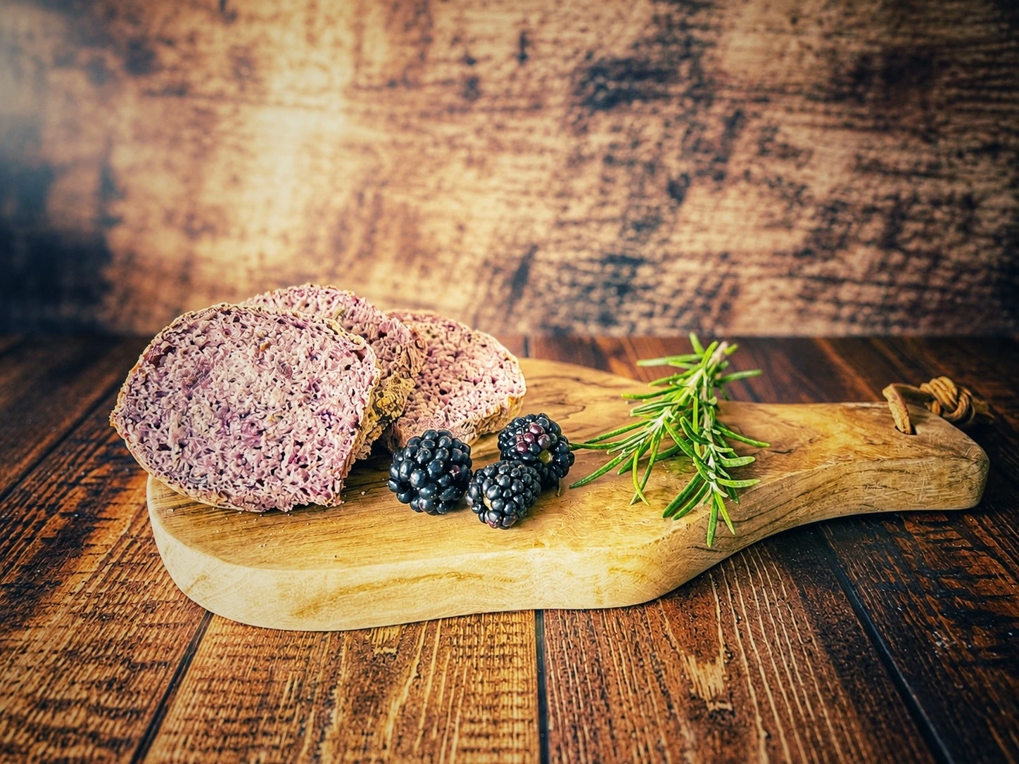 Brombeer-Rosmarin-Brot mit saftiger violetter Krume auf einem Holzbrett
