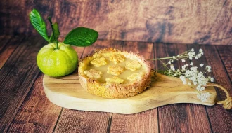 Pursha-Limetten-Tarte mit selbstgemachtem Pursha-Limetten-Curd auf einem Holzbrett mit frischen Pursha-Limetten